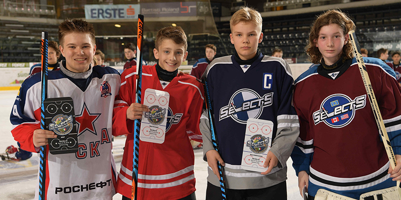Four players from various teams pose on the ice after being named to the World Selects Trophy Invitational All-Tournament Team