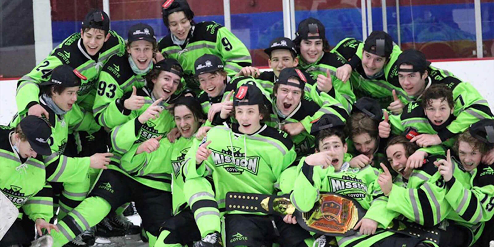 Sporting neon green jerseys, the 15U Chicago Mission hockey team poses on the ice for a championship photo.