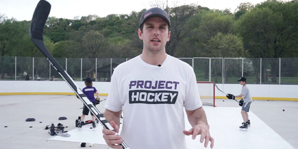Danny Heath from Project Hockey stands in front of an outdoor roller rink.