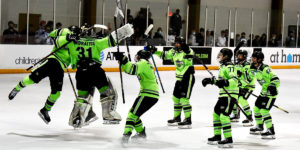 Players from the 2005 Chicago Mission hockey team rush to celebrate with their goalie after a win.