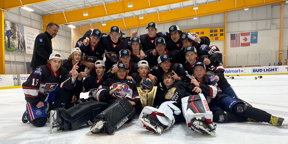 DraftDay Black poses on the ice for a championship photo after winning the 2021 World Selects Trophy